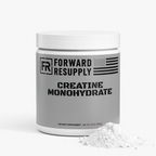 Creatine monohydrate supplement jar with white lid and powder pile beside