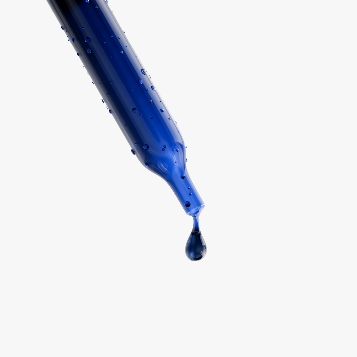 Blue liquid drop on the end of a dropper tip